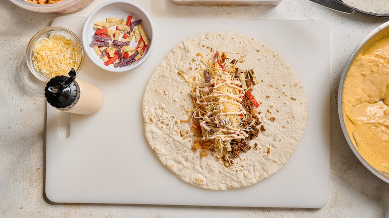 burrito with fillings on a cutting board