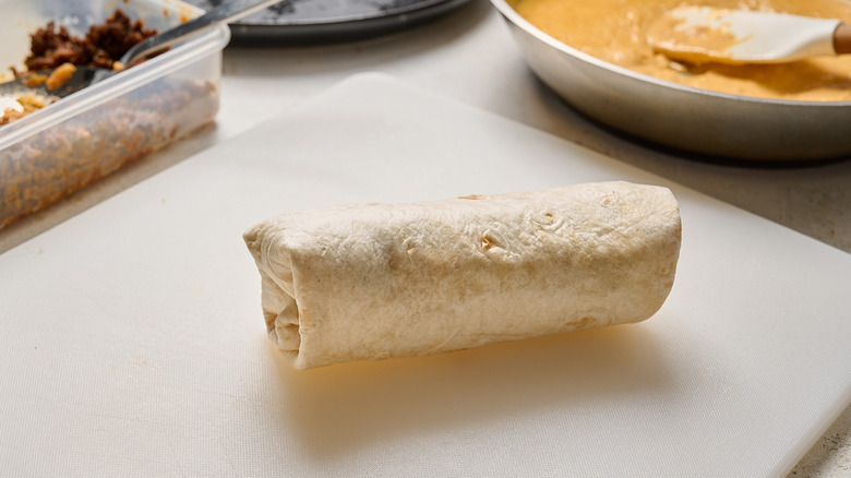 rolled burrito on a cutting board