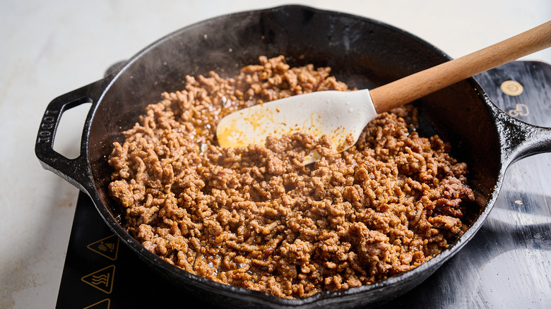 seasoning the beef in the skillet