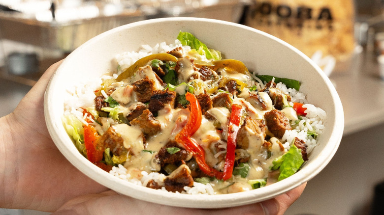Qdoba burrito bowl with chips and catering set up in the background