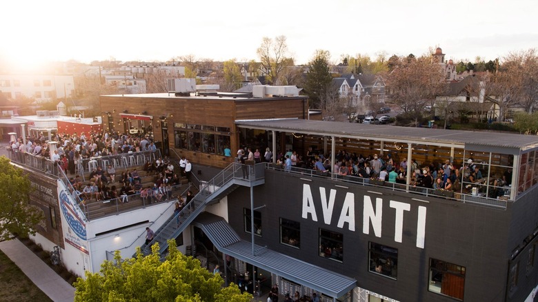 An outdoor patio full of people at sunset