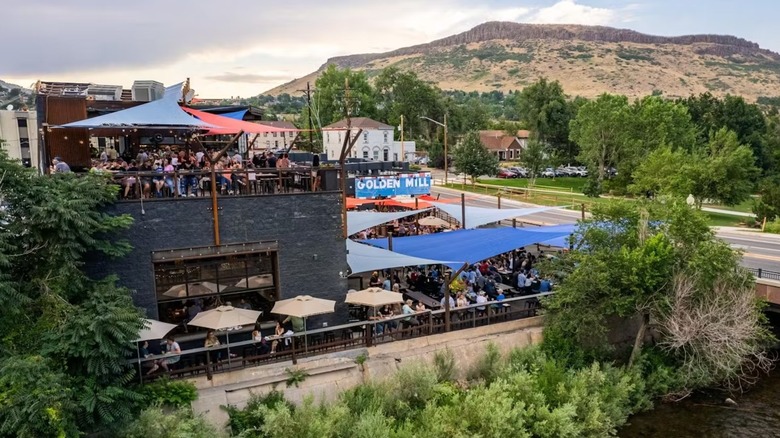 The outside of a black building with mountains in the background
