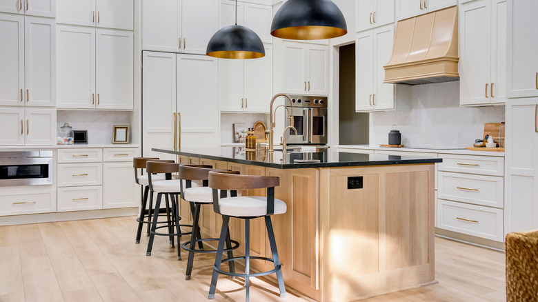 A beautiful white kitchen with a natural wood island in the middle