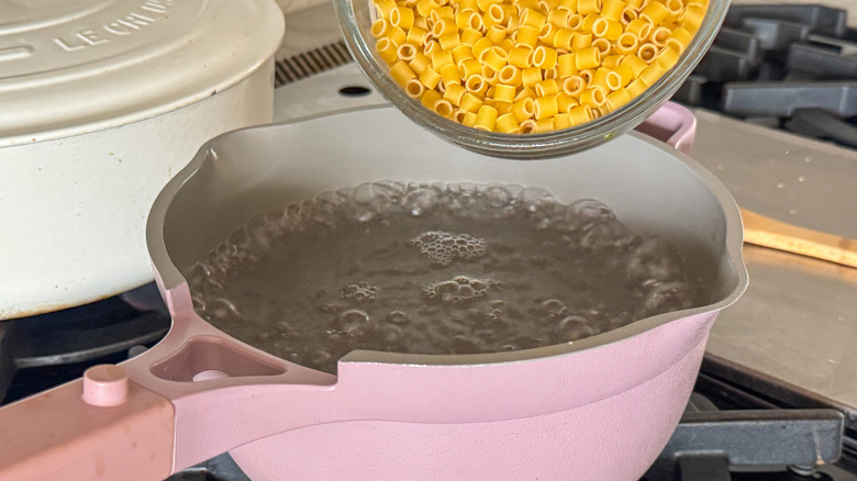 adding pasta to pot of boiling water