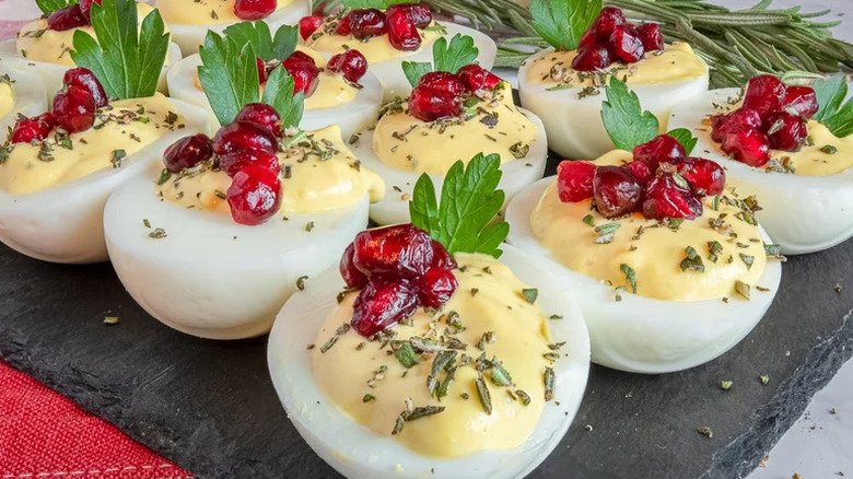 Christmas deviled eggs with pomegranate on a board