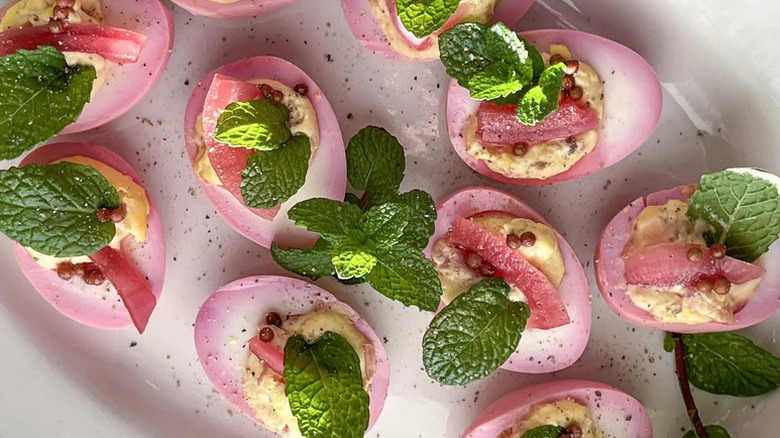 Eggscellent easter deviled eggs appetizer with mint on white plate