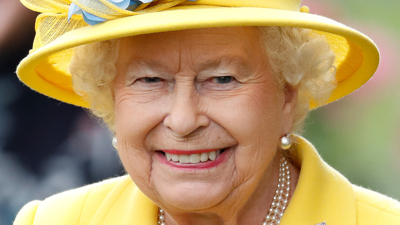Queen Elizabeth in yellow hat with blue flower