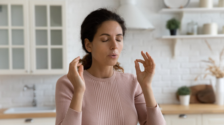 woman doing breathing exercise with eyes closed