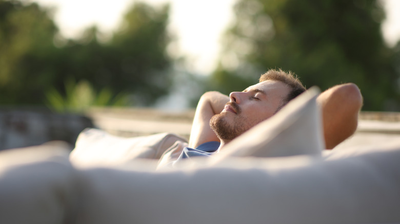 man relaxing on outdoor seating