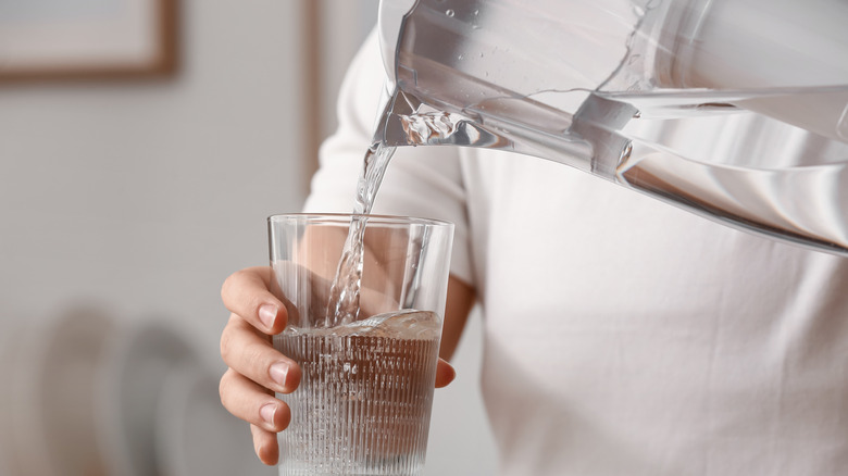 pouring glass of water from filter jug