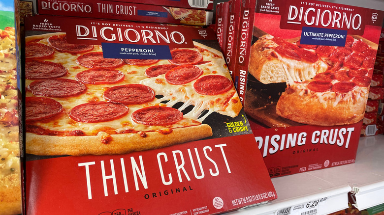 Boxes of frozen Digiorno pizzas on the freezer shelf.
