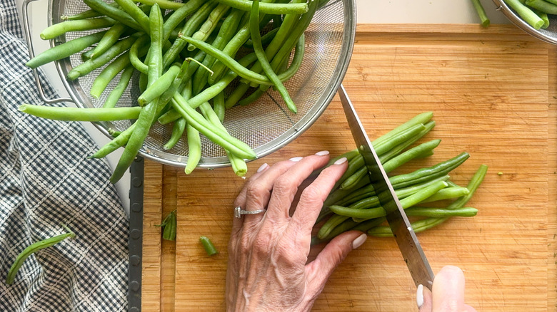 hands cutting green beans