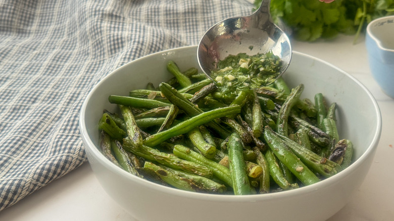adding sauce to green beans