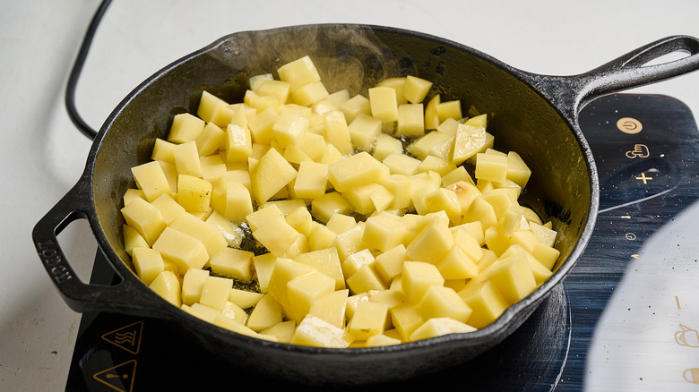 diced potatoes in a skillet with oil