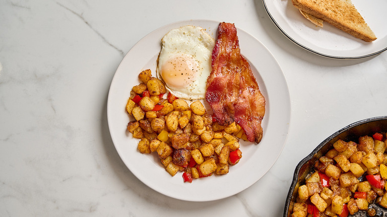 diner-style home fries served on a plate with eggs and bacon