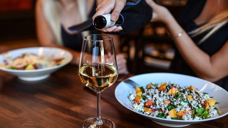 Woman pouring wine at restaurant table