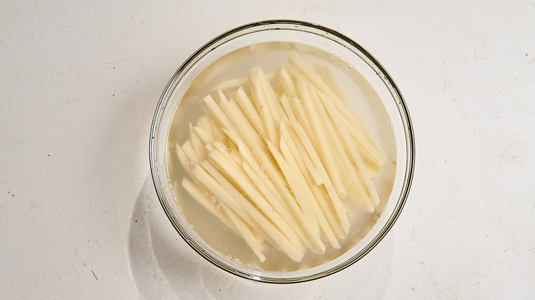 potatoes submerged in water in a bowl