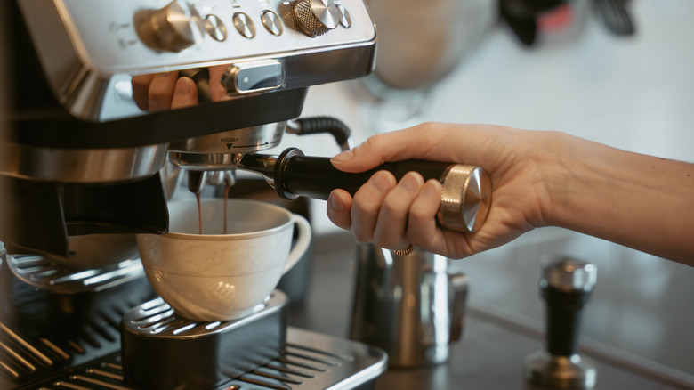 close up of someone making espresso with an espresso machine