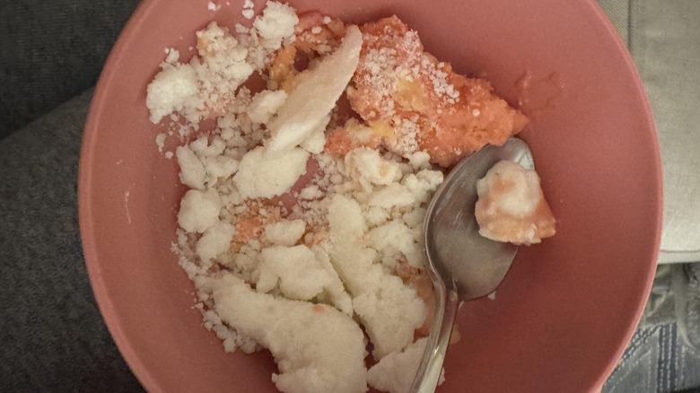 A pink bowl of dry, crumbly looking ice cream
