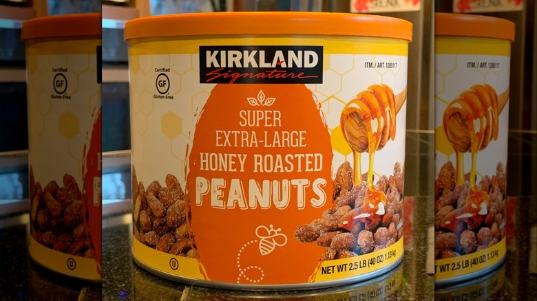 A yellow and orange can of Kirkland Signature Honey Roasted Peanuts.