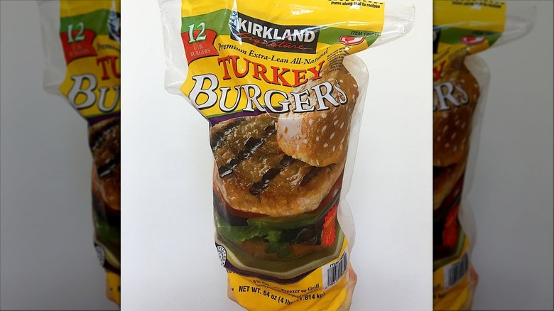 Yellow bag of Kirkland Signature Turkey Burgers from Costco on white background.