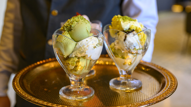 waiter holding two dishes of ice cream