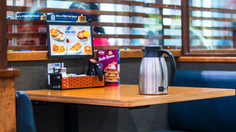 blue diner booth with a coffee kettle inside an IHOP restaurant