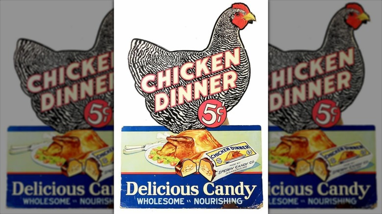 A vintage Chicken Dinner candy bar advertisement with a colorful chicken above the chocolate bar