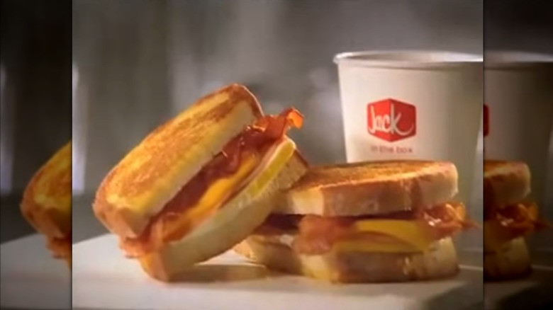Jack in the Box grilled breakfast sandwich next to cup of coffee