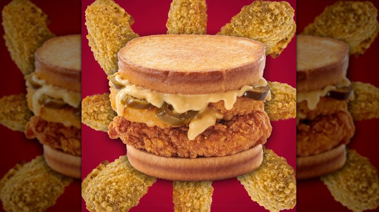 Spicy nacho chicken sandwich on red background with jalapeno poppers