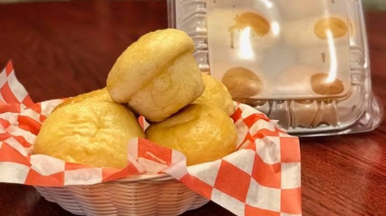Basket of dinner rolls and plastic package of rolls to go from Claudia Sanders Dinner House