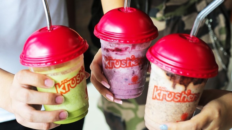 Three hands holding three flavors of KFC Krushers
