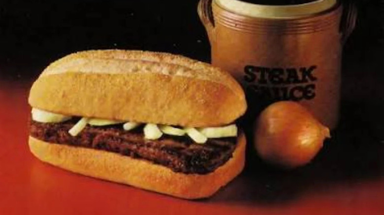 A close up of the Chopped Beefsteak Sandwich, with onions peeking out from beneath the bun from a McDonalds advertisement