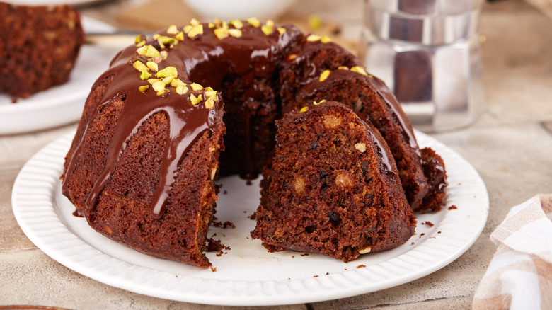 A chocolate Bundt cake with nuts and chocolate icing