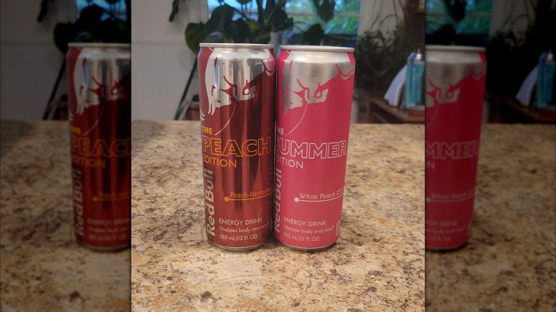 Two cans of peach Red Bull on kitchen counter, mirrored image