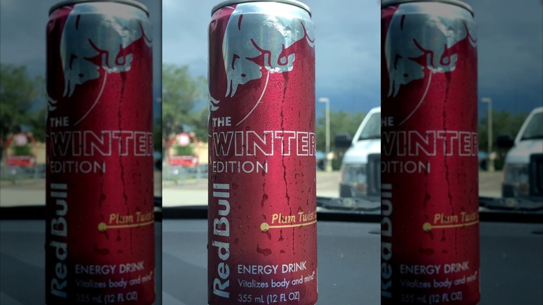 Mirrored image of Plum Twist Red Bull can on car dashboard