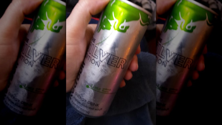 Mirrored image of hand holding Silver Edition Lime can