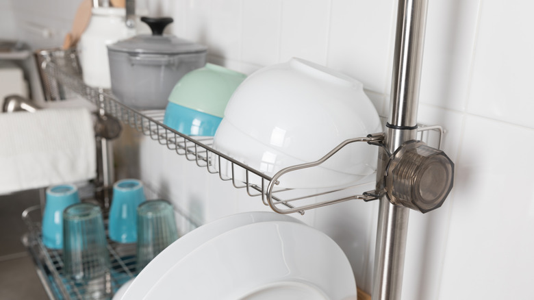 Dish rack with plates and bowls over sink