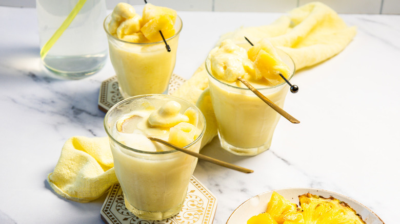 Three glasses of Dole Whip float with spoons.