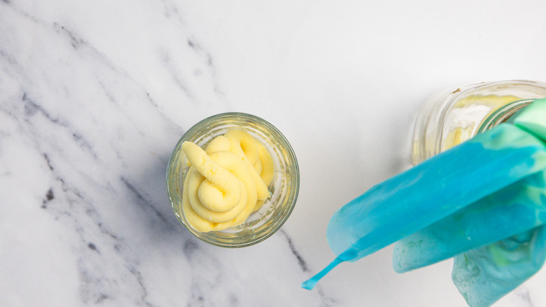 Piped Dole Whip ice cream in glass besides a piping bag.