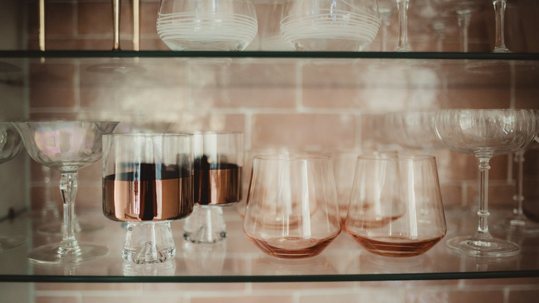 Assortment of drinking glasses on shelf.