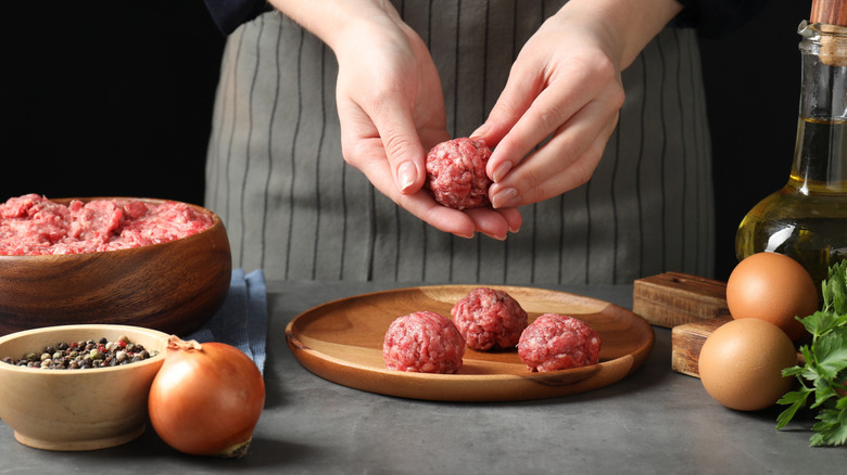 Closeup of person forming meatballs with raw ground beef
