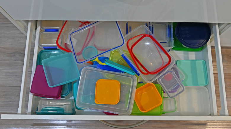 messy drawer full of plastic lids