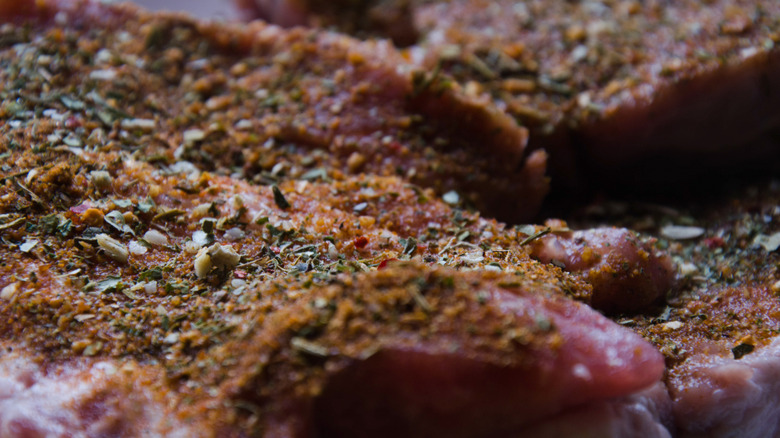 a close-up photo of ribeye steak heavily coated in dry rub spices