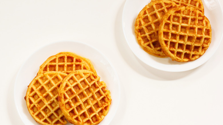 Two plates with a trio of cornbread waffles
