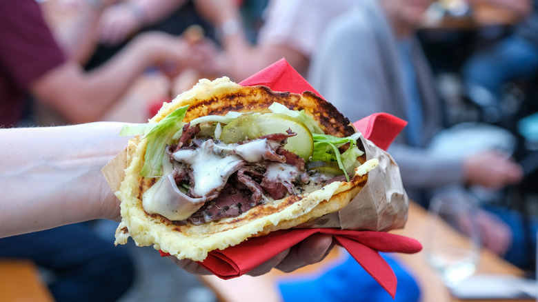 waffle taco in someone's hand with creamy sauce