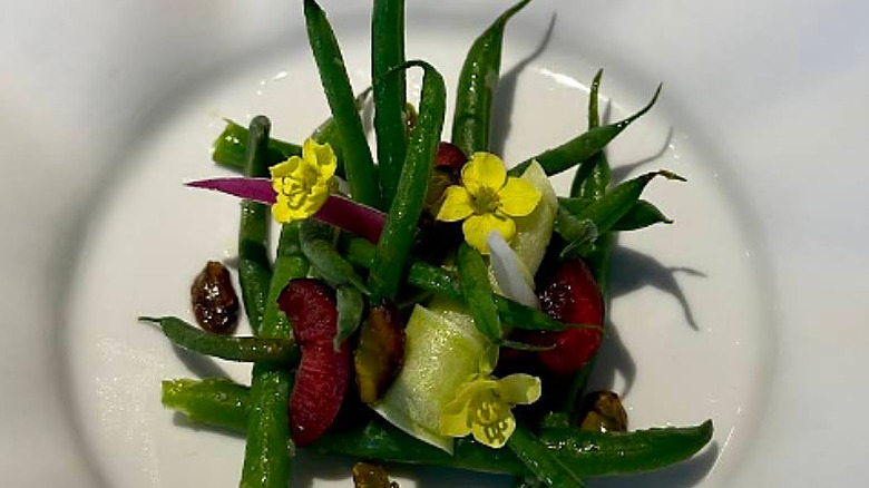 Green bean salad with edible yellow flowers at Mirazur