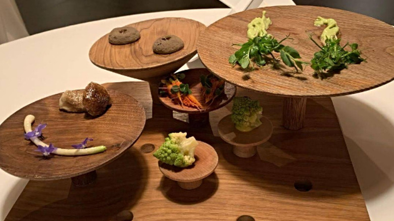 Minimalist dishes on a multi-tiered wooden board at Mugaritz Restaurant