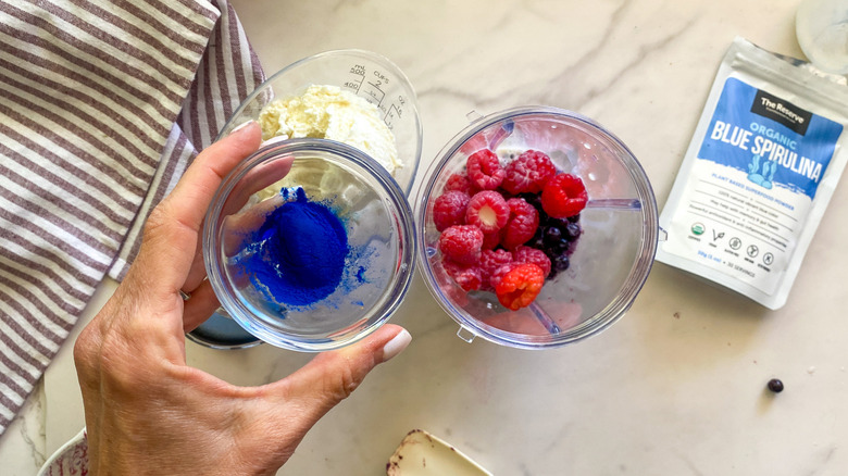 hand holding bowl of blue spirulina