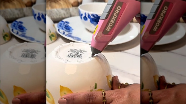 close up of a woman adding hot glue to the bottom of a bowl